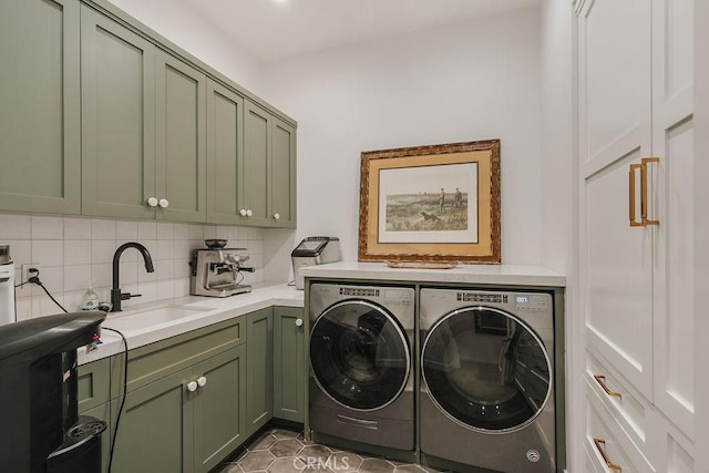 clothes washing area with cabinet space, a sink, and washer and clothes dryer