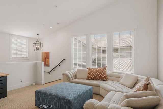living area featuring a chandelier, baseboards, vaulted ceiling, and light carpet
