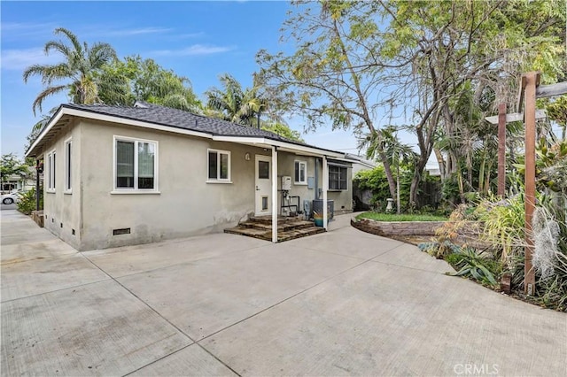 view of front of house with a patio, stucco siding, and crawl space