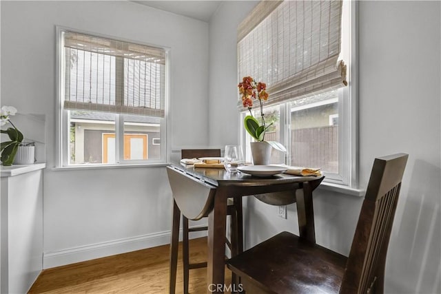 dining space featuring baseboards, plenty of natural light, and wood finished floors