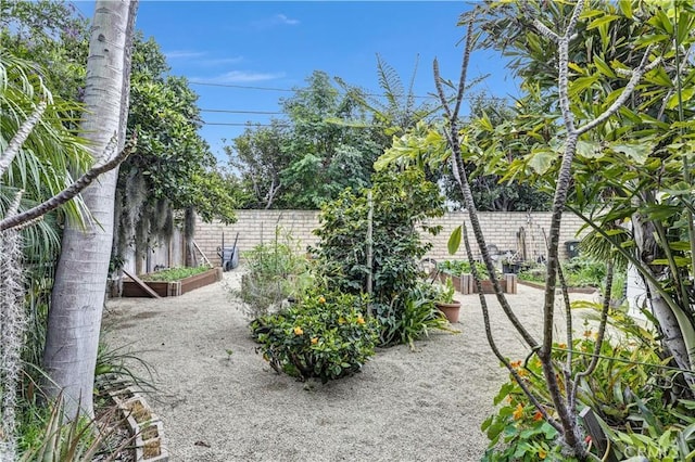 view of yard featuring a fenced backyard and a garden
