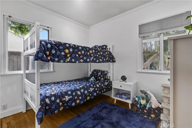 bedroom featuring crown molding, baseboards, multiple windows, and wood finished floors