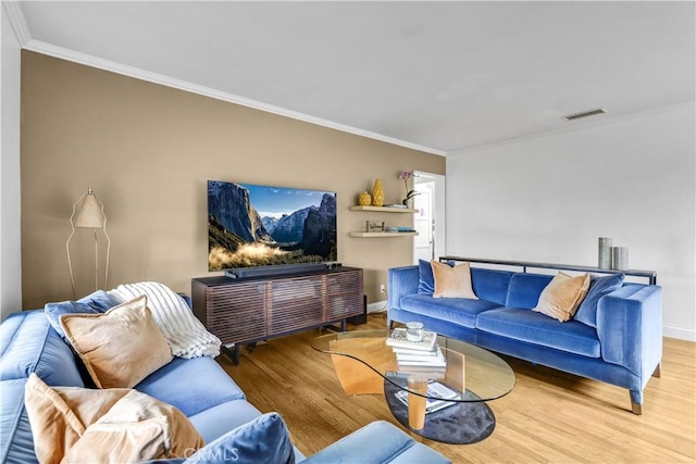 living area with visible vents, ornamental molding, baseboards, and wood finished floors