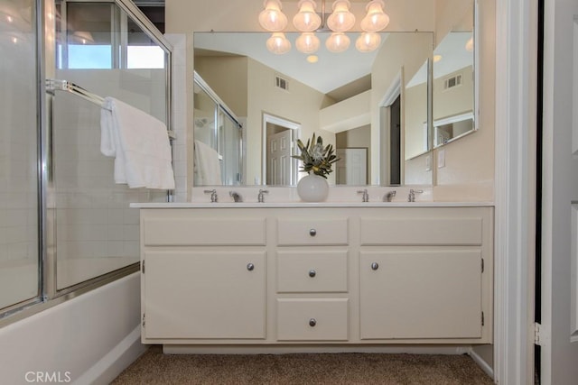 bathroom featuring visible vents, double vanity, and shower / bath combination with glass door