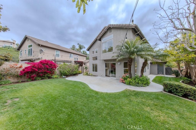 back of house with a lawn, a fenced backyard, a patio area, and stucco siding