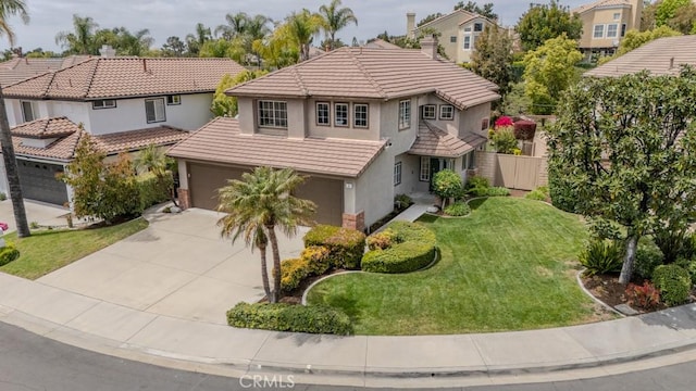 view of front of home featuring a tiled roof, a garage, a front lawn, concrete driveway, and stucco siding