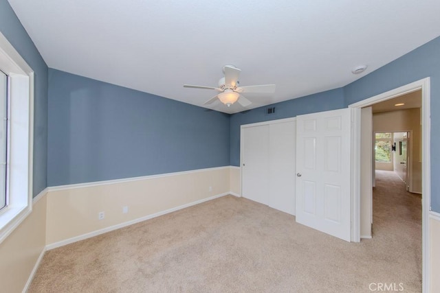 unfurnished bedroom featuring baseboards, carpet, a closet, and visible vents