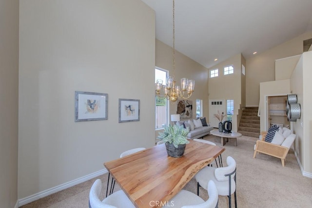 dining space with light colored carpet, stairway, high vaulted ceiling, baseboards, and a chandelier