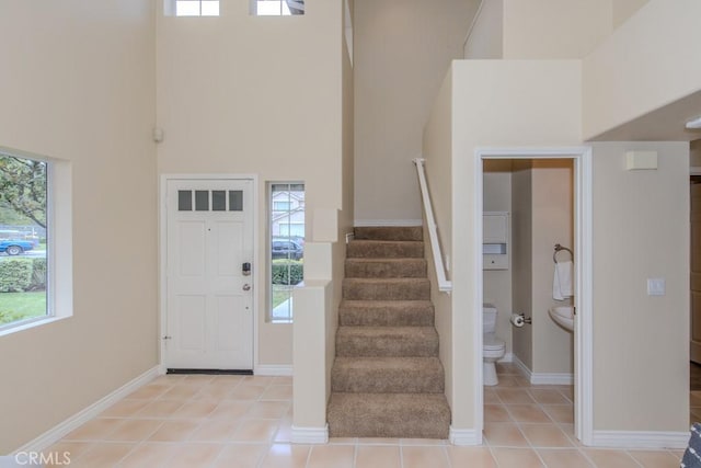 foyer entrance featuring stairway, a high ceiling, and plenty of natural light