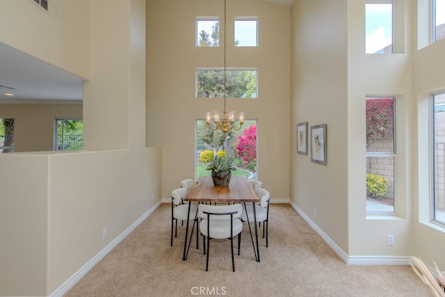 carpeted dining room featuring an inviting chandelier, baseboards, visible vents, and a towering ceiling