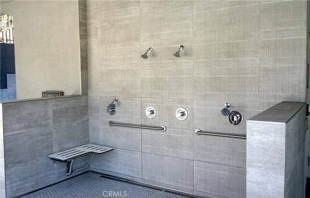 full bathroom featuring tile patterned flooring and tiled shower