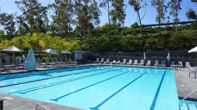 pool with a patio and fence