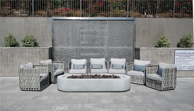 view of patio with an outdoor fire pit and fence