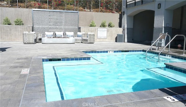 view of pool with a patio, fence, and a pool