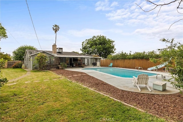 view of swimming pool with a fenced backyard, a fenced in pool, a water slide, a patio, and a lawn