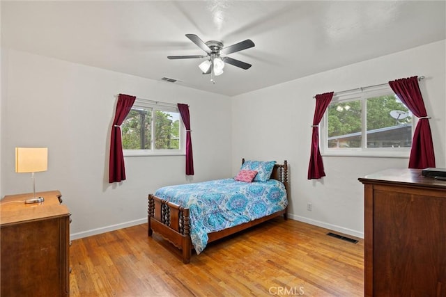 bedroom featuring baseboards, visible vents, and light wood finished floors
