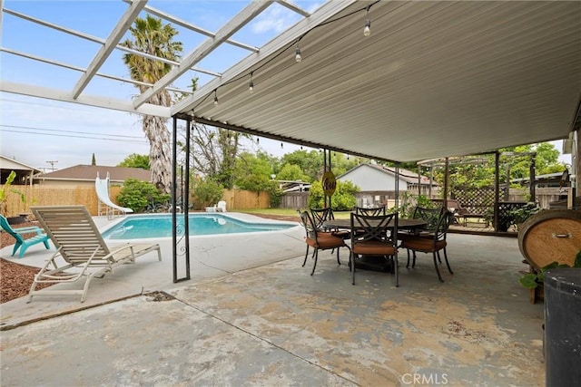 view of pool with a patio, outdoor dining area, a fenced in pool, a fenced backyard, and a water slide
