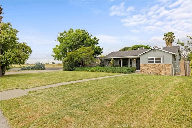 ranch-style home featuring a gate, stucco siding, a front yard, and stone siding
