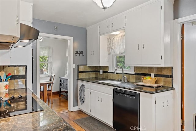kitchen with tasteful backsplash, black appliances, light wood-style floors, and a sink