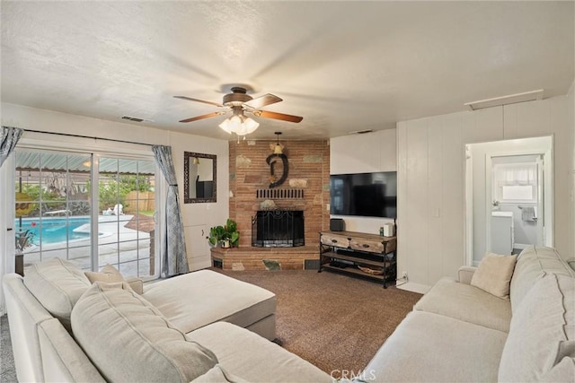 carpeted living area featuring a fireplace, ceiling fan, and visible vents