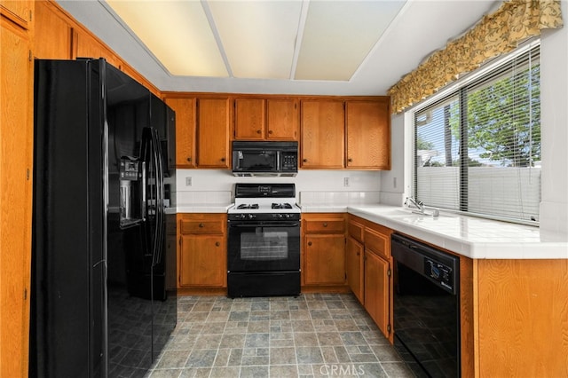 819 Miller Rd, Banning, CA 92220 - kitchen featuring black appliances, stone finish floor, brown cabinets, and a sink