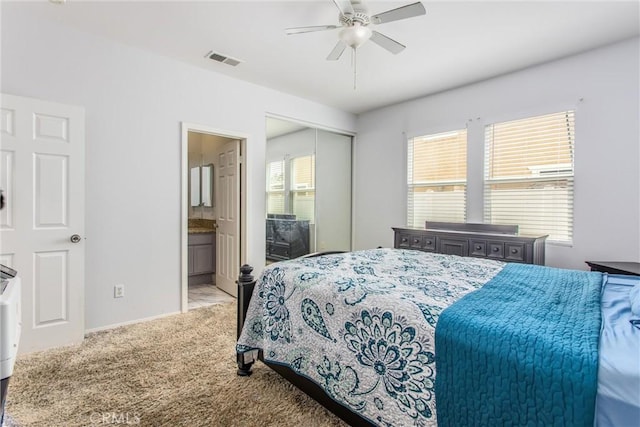bedroom with carpet flooring, visible vents, ensuite bathroom, baseboards, and a closet