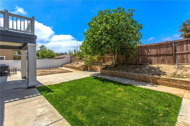 view of yard with a fenced backyard, a balcony, and a patio area