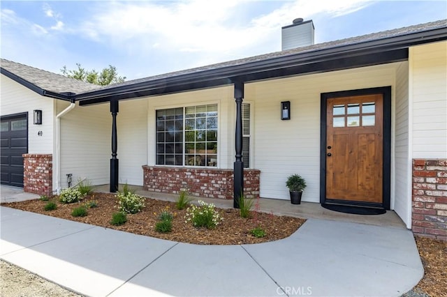 40 Frontier Way, Templeton, CA 93465 - property entrance featuring covered porch, brick siding, a garage, and a chimney