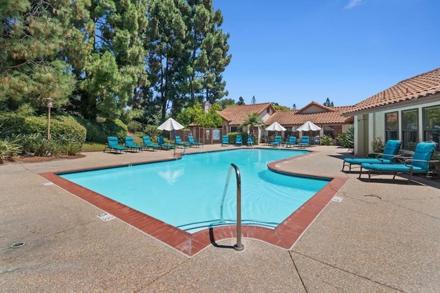 pool featuring fence and a patio area