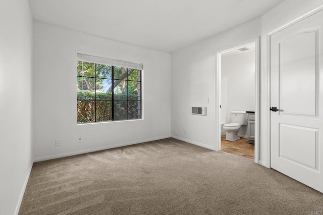 unfurnished bedroom featuring baseboards, ensuite bath, and carpet flooring