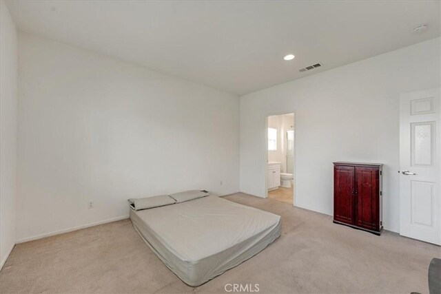 bedroom with recessed lighting, connected bathroom, visible vents, baseboards, and light colored carpet