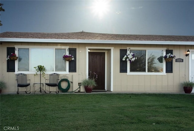 doorway to property with a lawn
