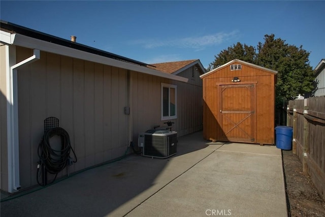 view of shed featuring fence and cooling unit