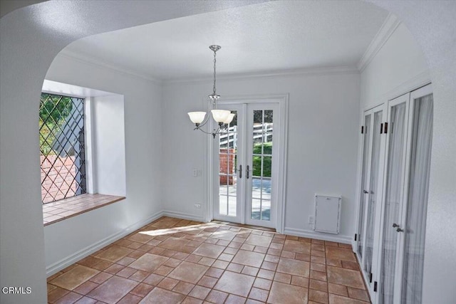 unfurnished dining area featuring baseboards, arched walkways, french doors, and crown molding