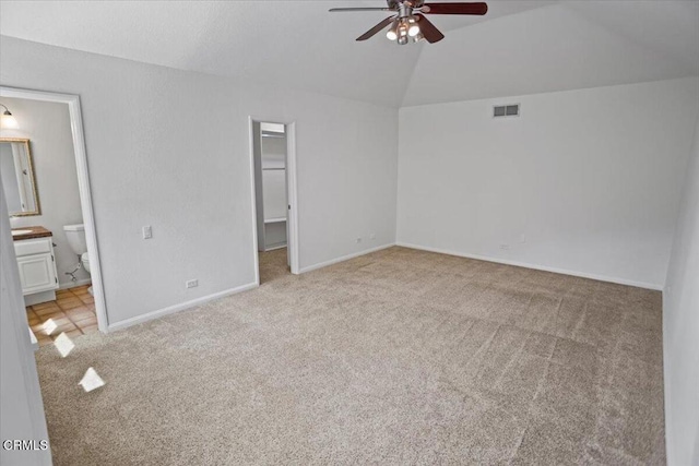 unfurnished bedroom with visible vents, vaulted ceiling, light carpet, and a spacious closet