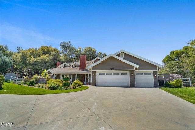 view of front facade with fence, concrete driveway, an attached garage, and a front lawn
