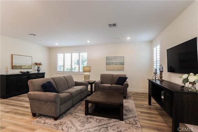 living area with visible vents, a healthy amount of sunlight, and light wood-style flooring