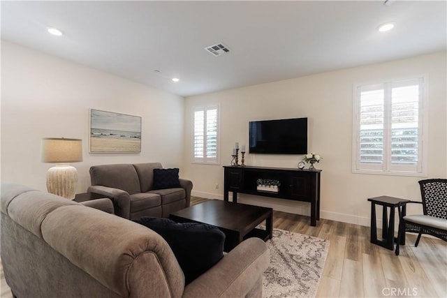 living room with visible vents, baseboards, recessed lighting, and light wood-style floors