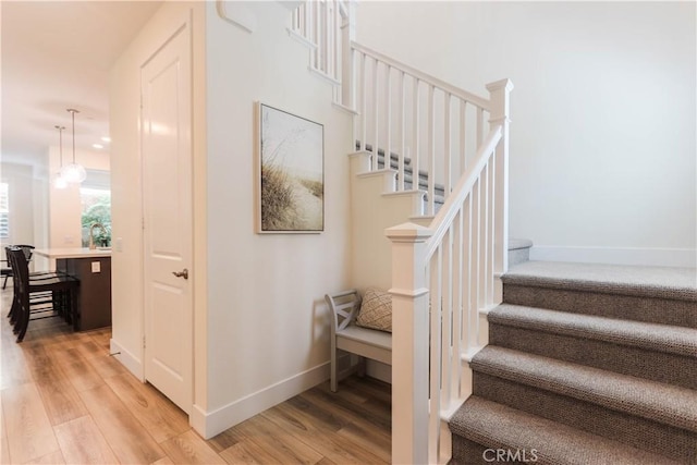 staircase with wood finished floors and baseboards