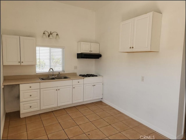 8581 Montara Rd, Pinon Hills, CA 92372 - kitchen with under cabinet range hood, light countertops, gas stovetop, white cabinetry, and a sink