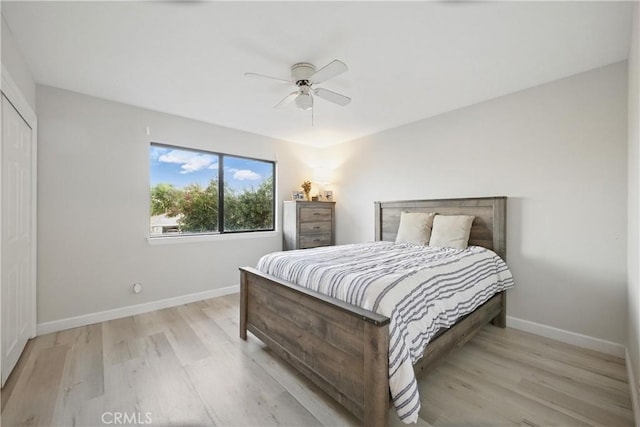 bedroom with ceiling fan, baseboards, and light wood-style floors