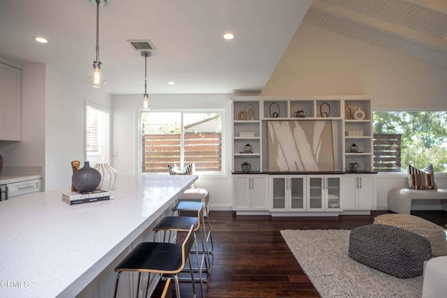 interior space with recessed lighting, a kitchen breakfast bar, white cabinetry, and dark wood finished floors