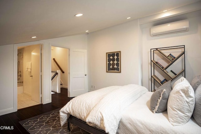 bedroom with wood finished floors, recessed lighting, and an AC wall unit