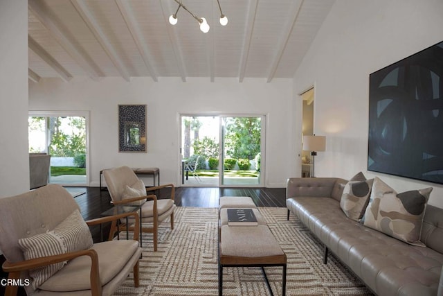 living room with a wealth of natural light, wood finished floors, and vaulted ceiling with beams