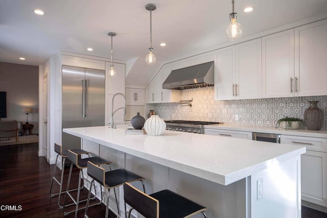 kitchen featuring wall chimney exhaust hood, recessed lighting, backsplash, and white cabinetry