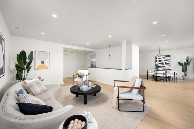 living room featuring recessed lighting, visible vents, and light wood-style flooring