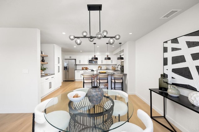 dining room featuring light wood-style floors, visible vents, baseboards, an inviting chandelier, and recessed lighting
