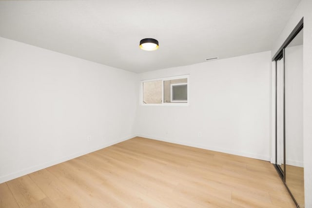 empty room with baseboards, visible vents, and light wood-style flooring