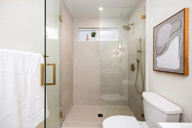 bathroom with a shower stall and toilet