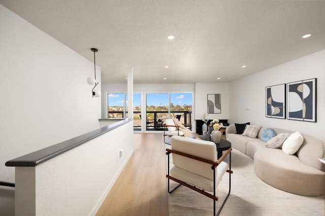 living area featuring recessed lighting, a textured ceiling, and light wood-type flooring